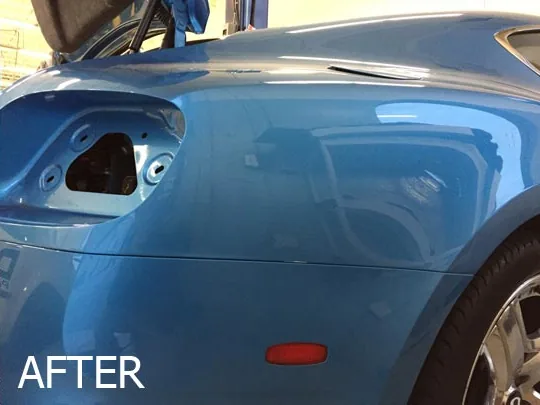 The same blue car quarter panel restored to a smooth finish after repair