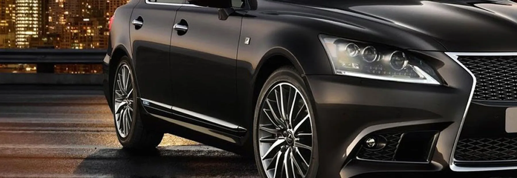 A glossy dark car panel reflecting warm light